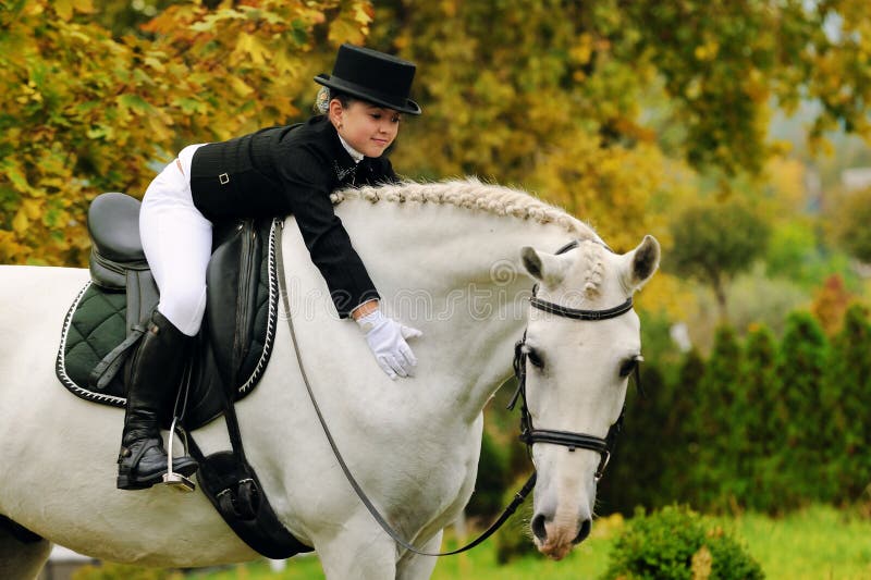 Young girl with white dressage horse