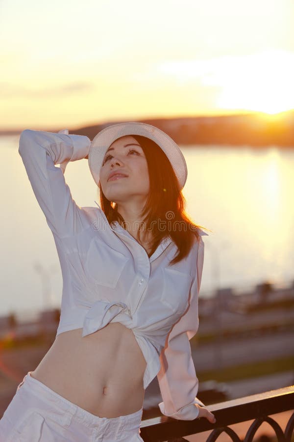 Joven en blanco camisas un sombrero, en atardecer.