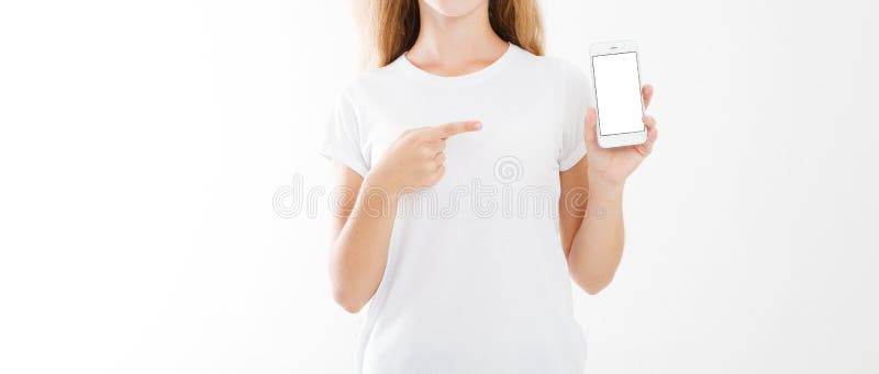 Young girl, woman in t-shirt pointing finger at blank screen mobile phone isolated on white background. Hand holding smartphone