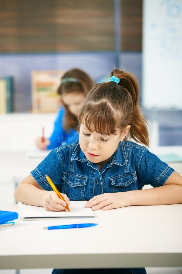 Young girl writing at school