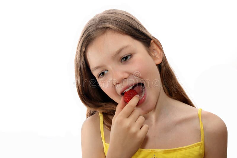 Young girls eats strawberry