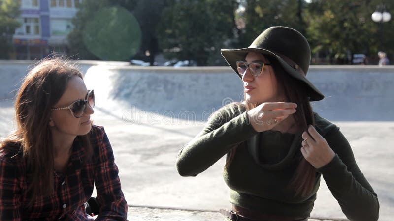 Young girls sit in the park in the fall and communicate