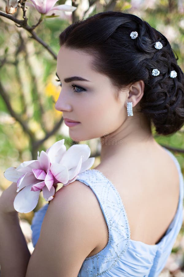 Young gorgeous woman with magnolia