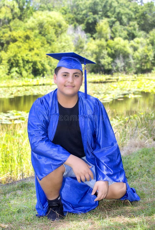 Young Graduate Proudly Sitting In A Nature Park With Cap And Gown royalty free stock photos Young Graduate Proudly Sitting In A Nature Park With Cap And Gown royalty free stock photos