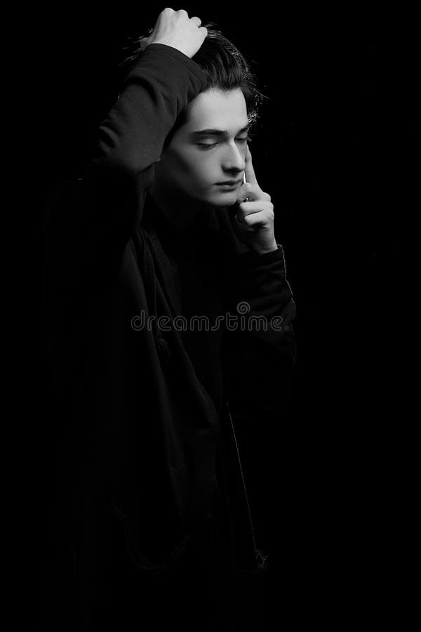 A Young Guy In A Black Hoodie On A Black Background With His Face