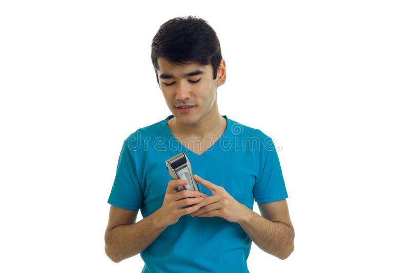 A Young Guy in the Blue Shirt Holding a Clipper To Shave Stock Image ...