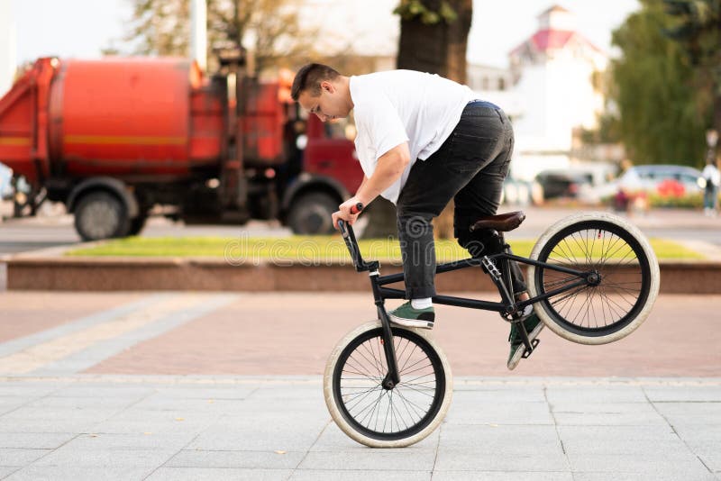 A young guy on a BMX bike, rides on the front wheel, braking with his foot royalty free stock photos A young guy on a BMX bike, rides on the front wheel, braking with his foot royalty free stock photos