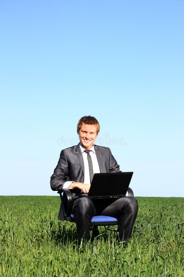 Young guy businessman. In the suit, on the field