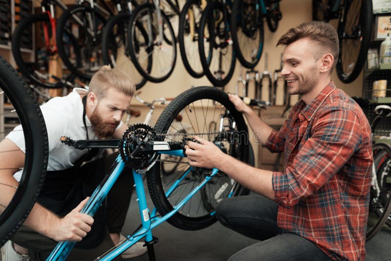 A young guy came to the workshop to repair his bicycle. royalty free stock photo A young guy came to the workshop to repair his bicycle. royalty free stock photo