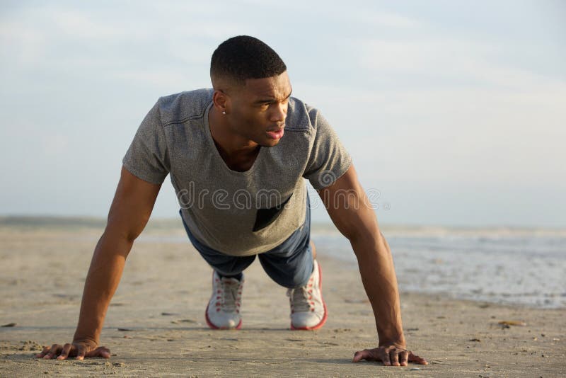 Young guy doing push ups at the beach royalty free stock photography
