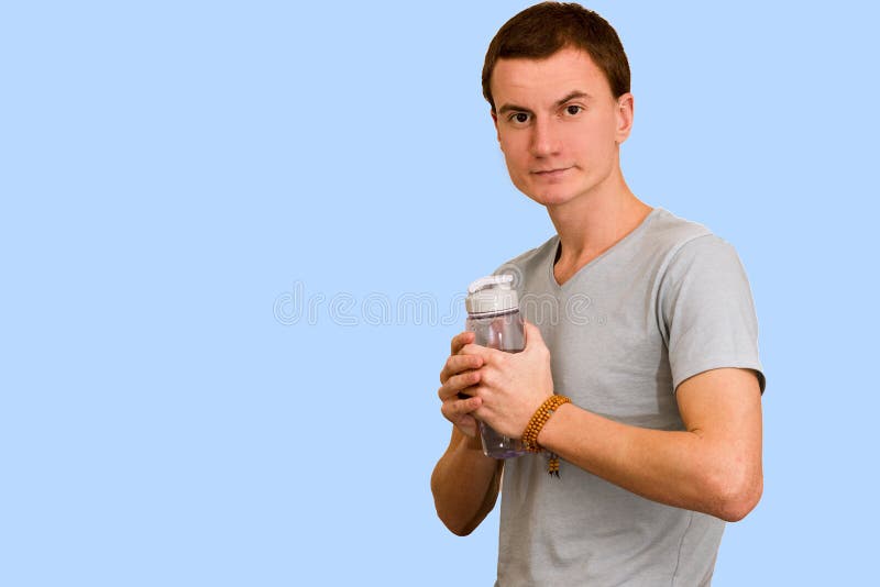 A Young Guy Holds A Bottle Of Water In His Hand Stock Photo Image Of