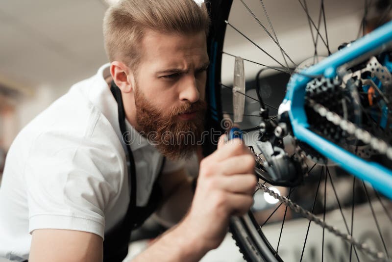 A Young Guy Repairs a Bicycle. Stock Photo Image of modern, repair