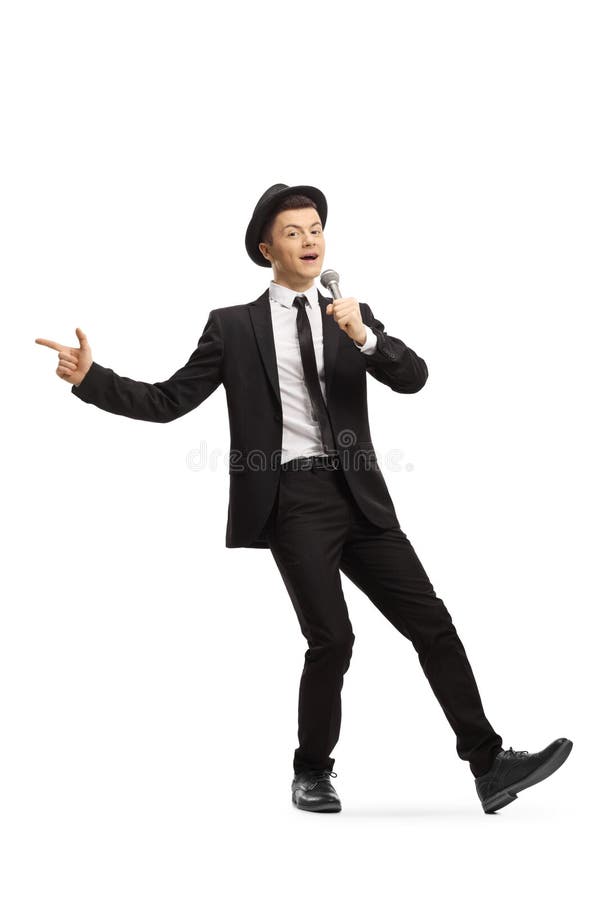 Young Guy in a Suit and Hat Dancing and Singing on a Microphone Stock