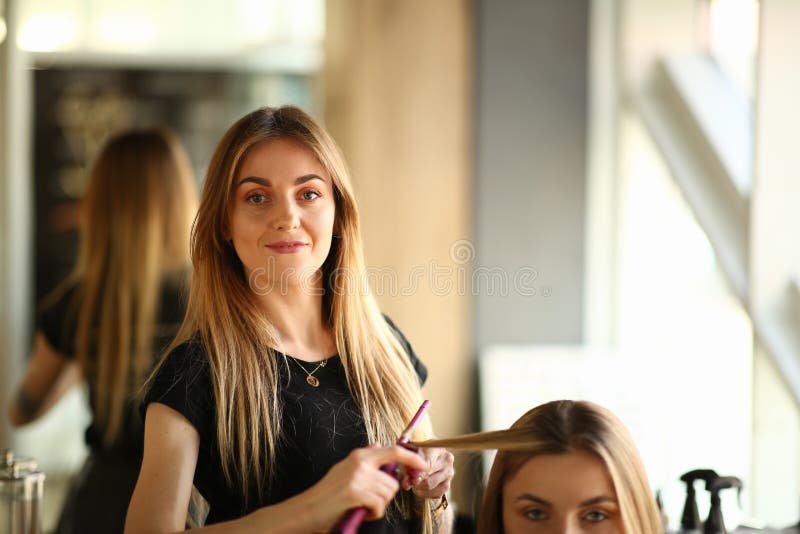 Young Hairstylist Making Curls for Girl Client stock photos Young Hairstylist Making Curls for Girl Client stock photos