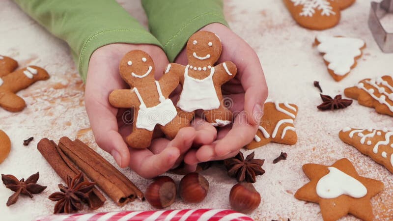 Young hands holding gingerbread people christmas cookies stock video