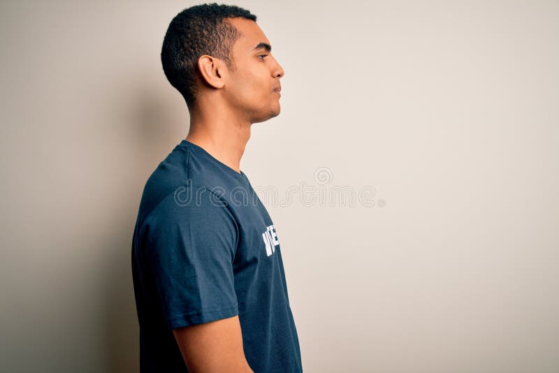 Young handsome african american man volunteering wearing t-shirt with volunteer message looking to side, relax profile pose with