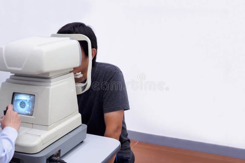 Asian man take eye exam with optical eye test machine