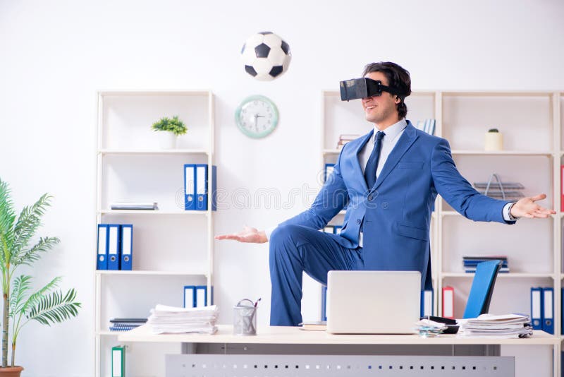 The Young Handsome Businessman Playing Soccer with Virtual Glasses