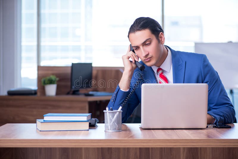 Young handsome businessman sitting in the office royalty free stock photo Young handsome businessman sitting in the office royalty free stock photo