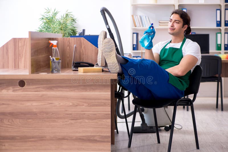 Young handsome contractor cleaning the office royalty free stock image Young handsome contractor cleaning the office royalty free stock image
