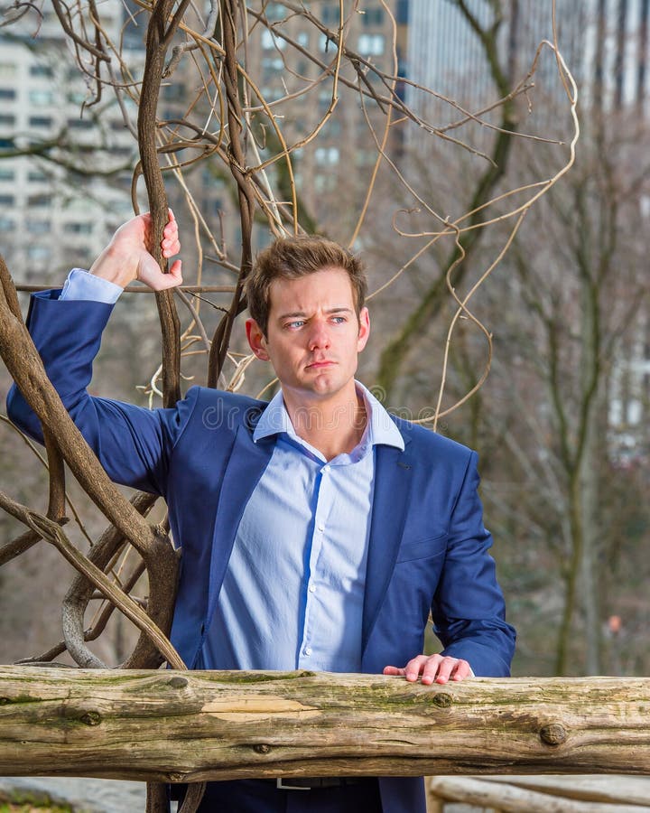Young Man standing outdoors in winter, thinking stock photo