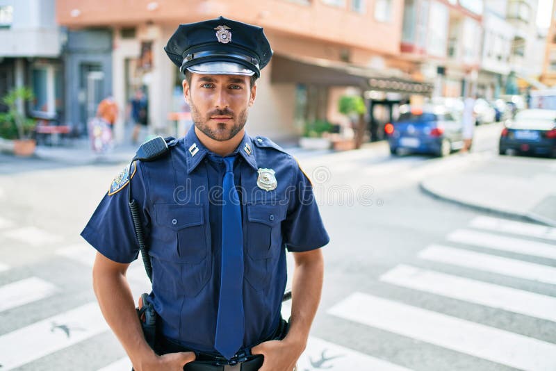 young handsome hispanic policeman wearing police uniform