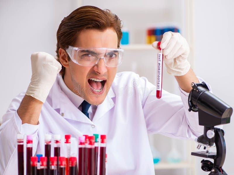 Young Handsome Lab Assistant Testing Blood Samples In Hospital Stock
