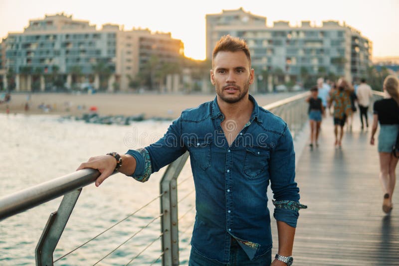 A young handsome man on the bridge near beautiful beach. stock photography A young handsome man on the bridge near beautiful beach. stock photography