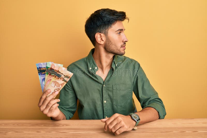 cheerful girl sitting on chair in lotus pose, holding laptop and credit card  near collection of Stock Photo by LightFieldStudios