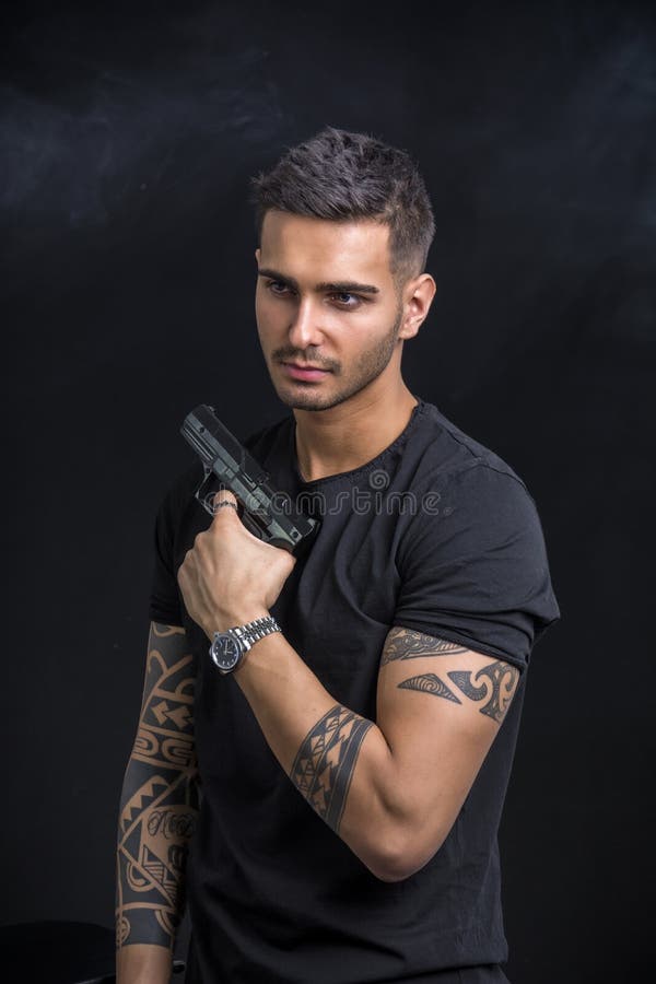 Young man holding hand gun