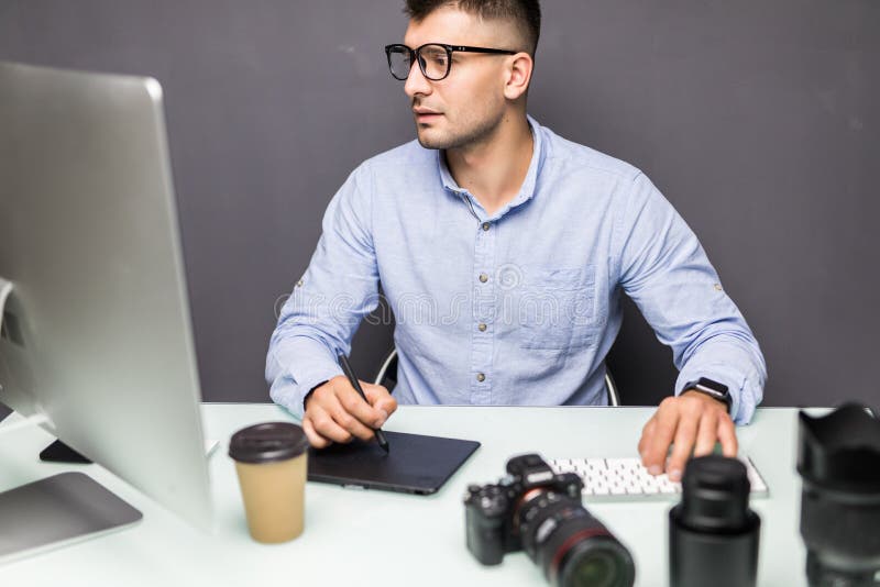 Young Handsome Man Photo Editor Using Graphics Tablet in Office Stock