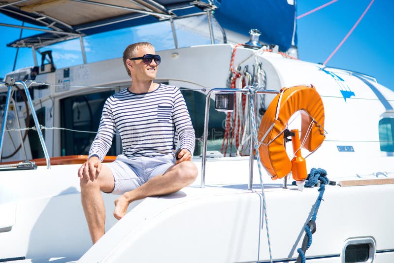 Young and handsome man relaxing on a sailing boat.