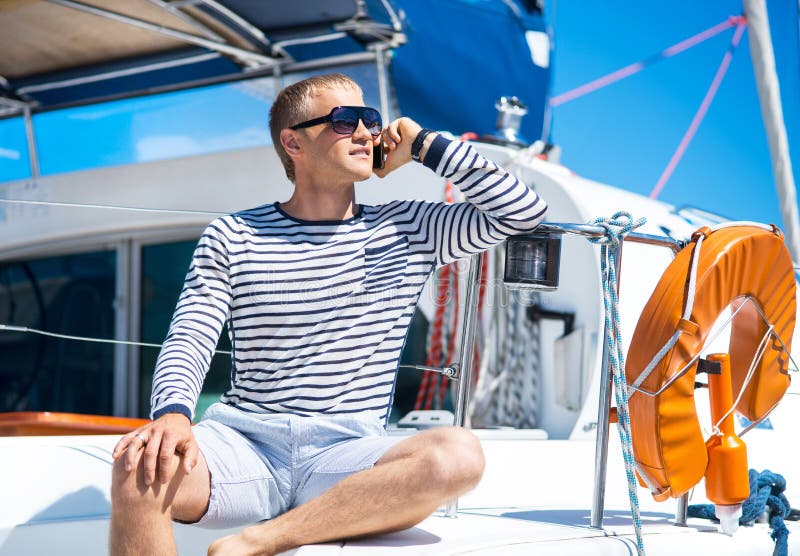 Young and handsome man relaxing on a sailing boat.