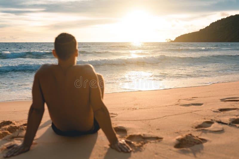 Young handsome man siting at the lazy beach royalty free stock image