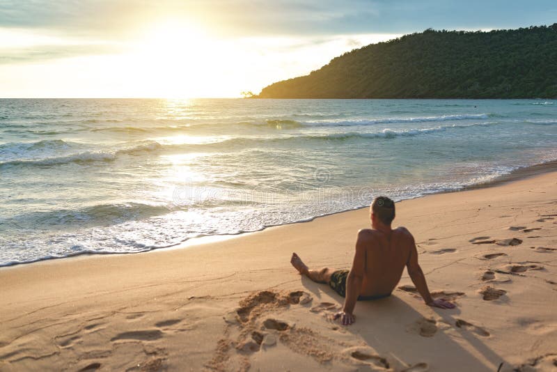 Young handsome man siting at the lazy beach royalty free stock photography