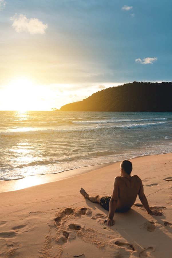 Young handsome man siting at the lazy beach stock photography
