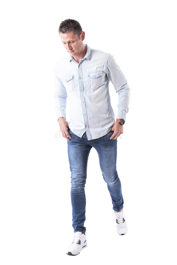 Young Handsome Man Walking with Hands in Pockets and Looking Down