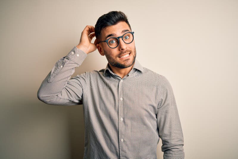 Young handsome man wearing elegant shirt and glasses over isolated white background confuse and wonder about question