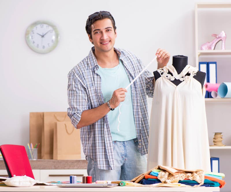 Young handsome tailor working in his workshop stock photo