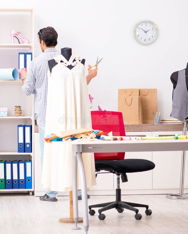 Young handsome tailor working in his workshop stock photos