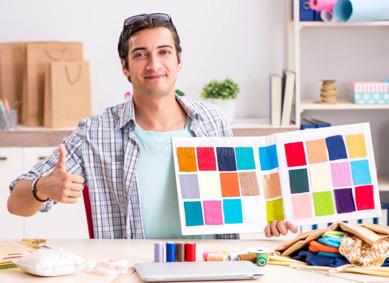 Young handsome tailor working in his workshop stock photography