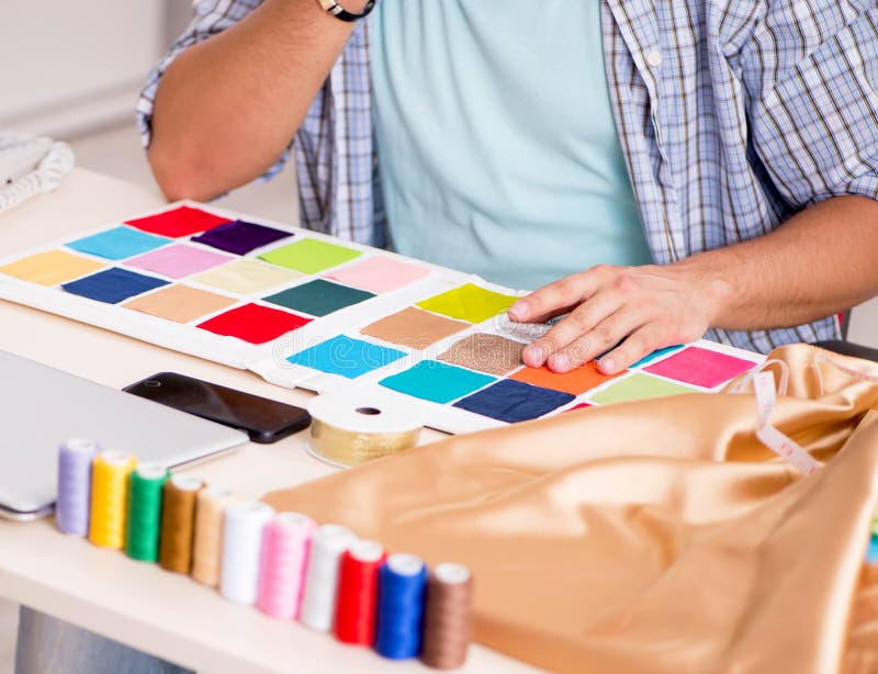 Young handsome tailor working in his workshop stock photos