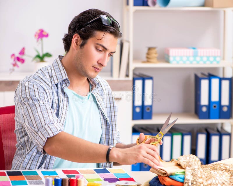 Young handsome tailor working in his workshop royalty free stock image