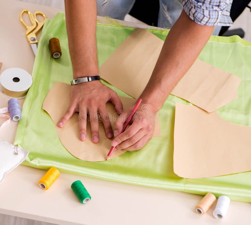Young handsome tailor working in his workshop royalty free stock photo