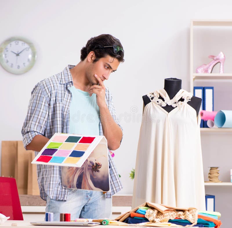 Young handsome tailor working in his workshop stock image