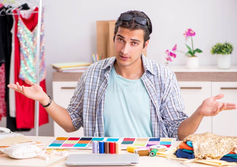 Young handsome tailor working in his workshop stock photo