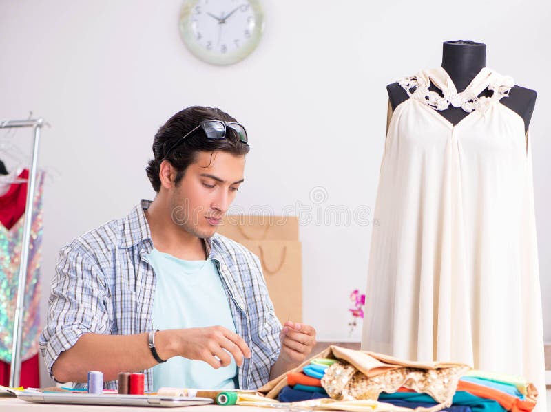 Young handsome tailor working in his workshop royalty free stock photo