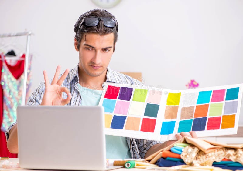 Young handsome tailor working in his workshop stock images