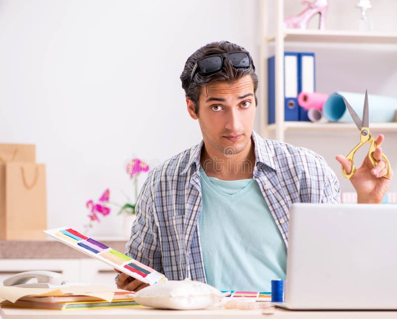 Young handsome tailor working in his workshop royalty free stock image