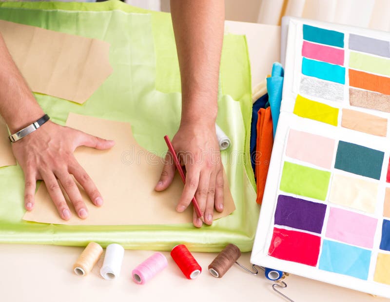 Young handsome tailor working in his workshop royalty free stock photo